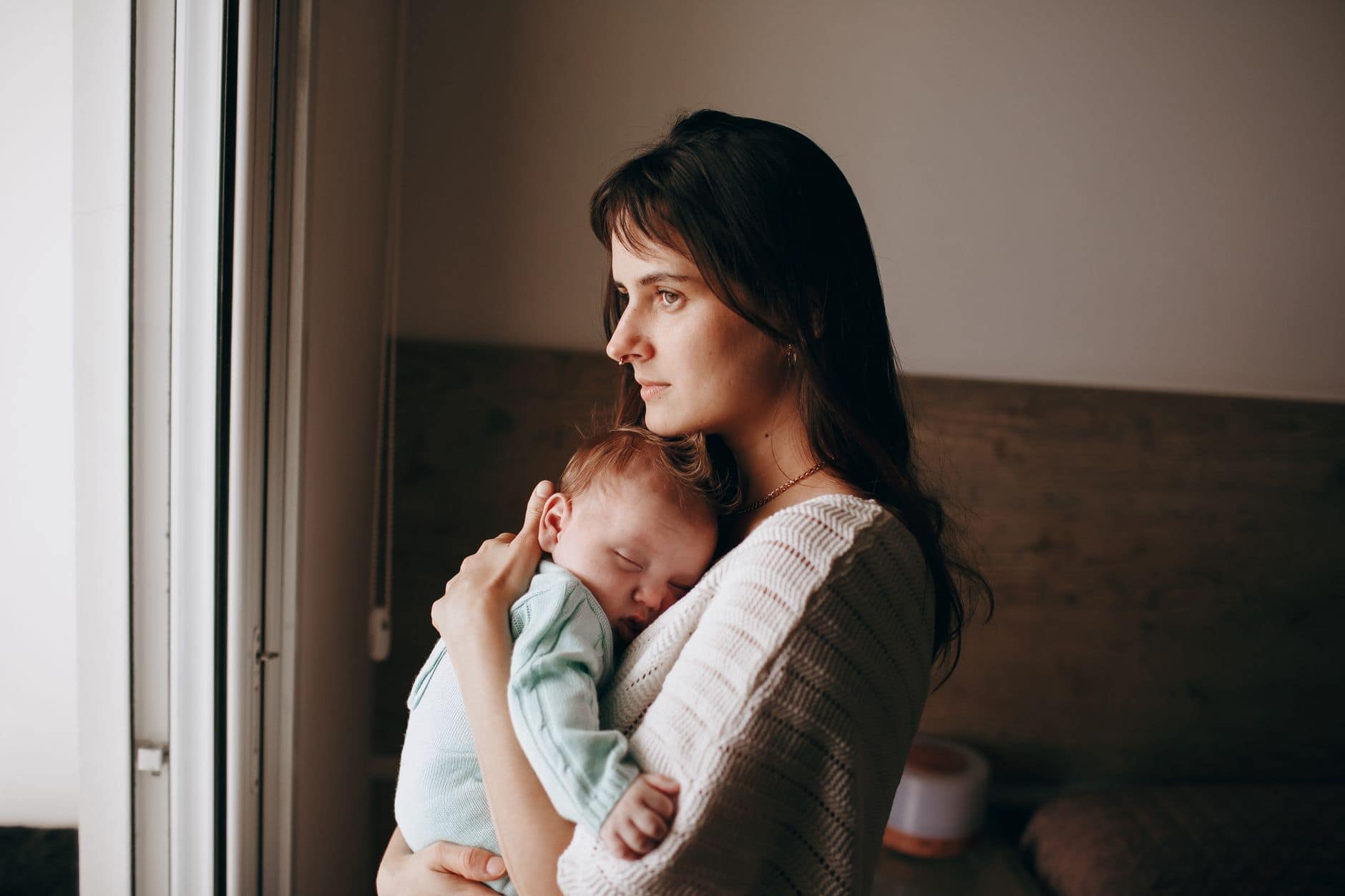mother standing and hugging newborn