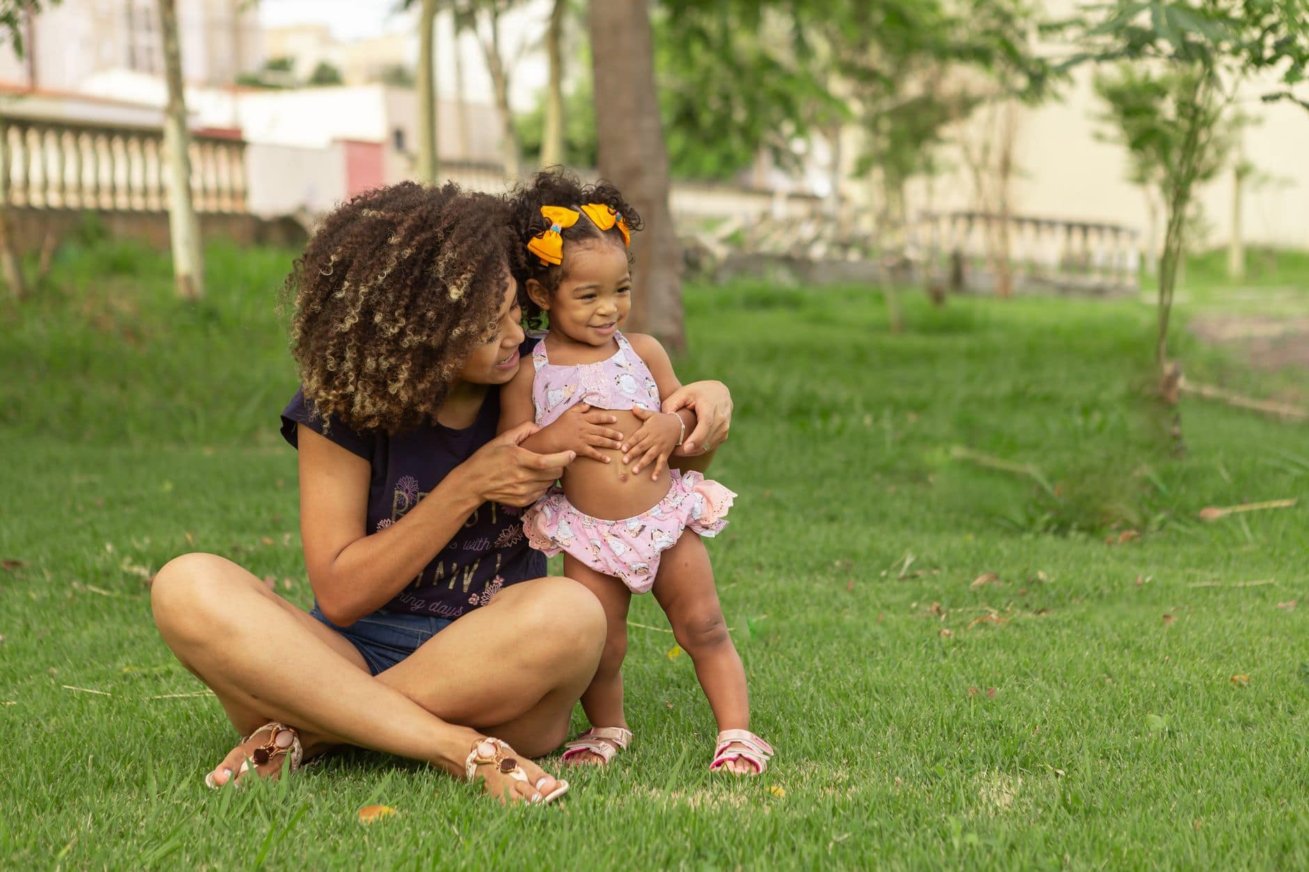 mother and daughter sitting on grass